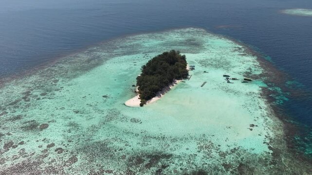 Stunning aerial footage of Cemara Kecil Island, Karimunjawa Indonesia with crystal clear water, white sandy beach, lush pine trees and tropical paradise scenery.