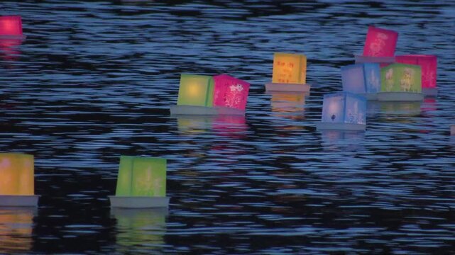 夕暮れの川面を静かに漂う日本の伝統的な灯籠流しの幻想的な光景