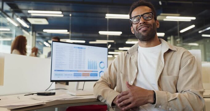 Analyst man in office reviews computer dashboard report. Financial charts and KPI reports on monitor support budgeting and tracking in an office. Concept shows financial data analysis.