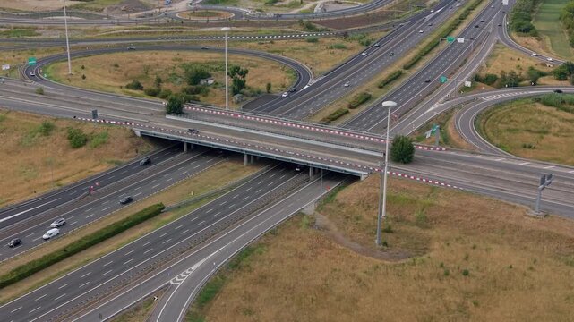 Aerial view of the A51 motorway interchange near Milan, Italy, showing multiple roads and active traffic flow across the urban transportation network.