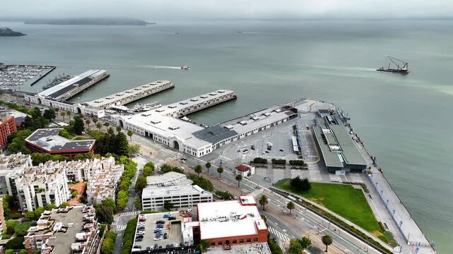 Aerial drone footage of San Francisco, California, overlooking a busy waterfront marina, yacht harbor, boats, piers and the San Francisco Bay. Scenic cinematic cityscape showing the relationship betwe