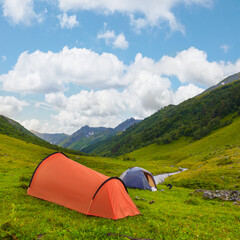 touristic camp stay among green mountains, summer mountain travel scene © Yuriy Kulik