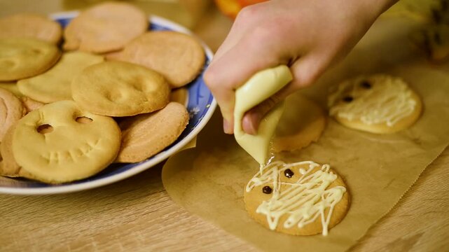 Macro view of applying white chocolate frosting on a shortbread cookie