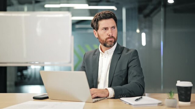 Professional concentrates on laptop. Suddenly startled by loud sounds. Covers ears, reacting with distress, shouting in frustration. Shows feeling of overwhelm and discomfort.