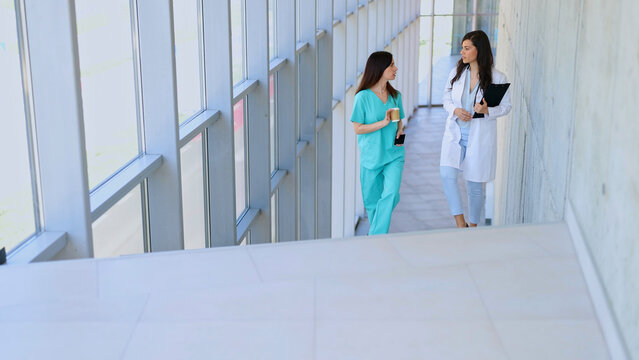 Medical professionals walking discussing healthcare in hospital hallway