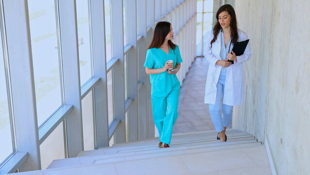 Healthcare professionals walking down stairs collaborating and communicating