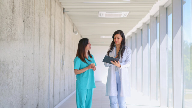 Medical professionals discussing patient records in hospital corridor