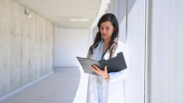 Female doctor analyzing patient medical records in clinic
