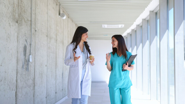 Healthcare professionals walking and talking in hospital corridor