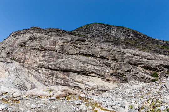 Gorge side with massive smooth granite rocks against clear sky
