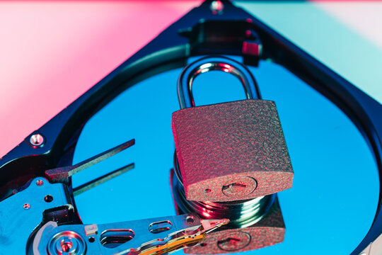 a metal padlock locking computer hard disk drive HDD components as a conceptual metaphor for cyber security data encryption privacy ransomware attack cloud storage defense and network safety