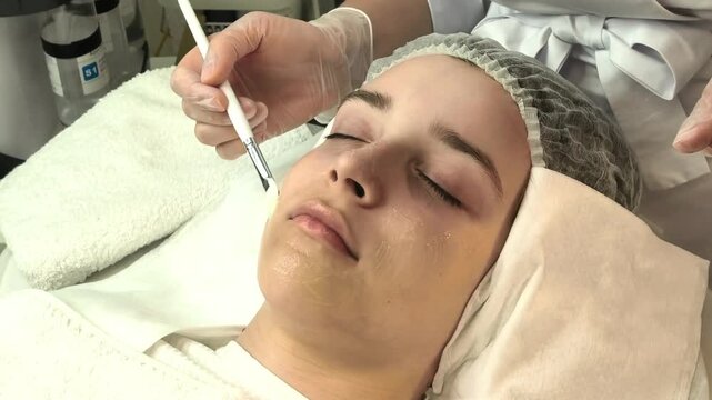Teenage girl receives a professional facial treatment in a beauty clinic, youthful skincare, gentle cosmetic care, relaxation and healthy complexion.