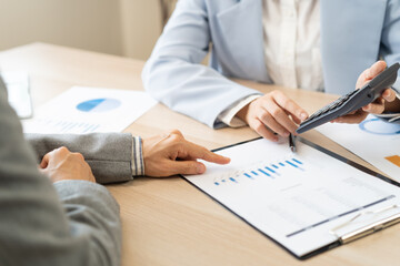Business meeting, asian group brainstorm analysis on graph data of cost plan. financial consult...