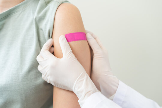 Vaccination coronavirus, hand of doctor apply plaster, bandage after doctor giving vaccine, injection dose on arm patient, immunization disease prevention against flu pandemic influenza, health care.
