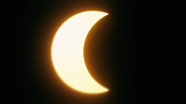 Solar eclipse with the moon crossing in front of a glowing golden sun, seamless loop for astronomy and space backgrounds