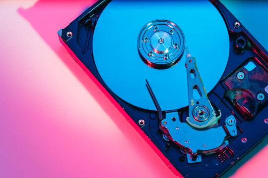 opened computer hard disk drive HDD internal components focusing on plattered disk and actuator read write head arm as a conceptual metaphor for cyber security big data cloud computing infrastructure 