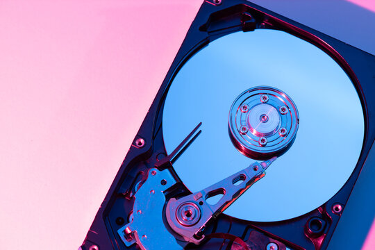 opened computer hard disk drive HDD internal components focusing on plattered disk and actuator read write head arm as a conceptual metaphor for cyber security big data cloud computing infrastructure 