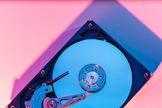 opened computer hard disk drive HDD internal components focusing on plattered disk and actuator read write head arm as a conceptual metaphor for cyber security big data cloud computing infrastructure 