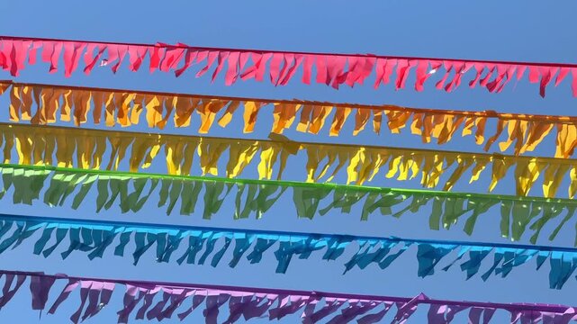 Rainbow garlands decoration fluttering in the wind over pride festival street in June