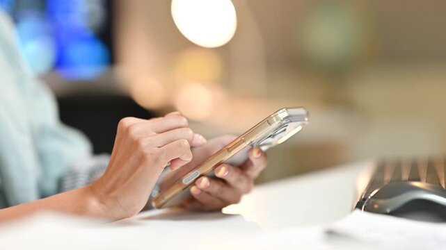 Woman Using Smartphone at Restaurant Table with Cutlery in Foreground, Close Up of Hands Typing