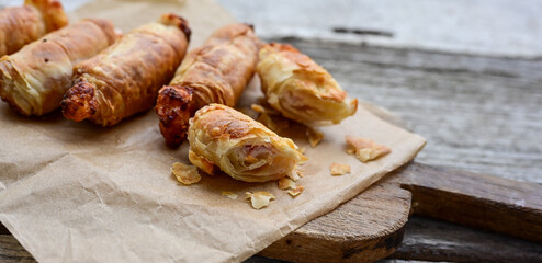 Fototapeta premium Greek style Mini filo pastry rolls with bacon and cheddar cheese .Home made bakery .Fresh baked Mini cheese ,meat and herbs puff pastries