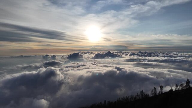 Aerial view of Mount Agung rising above a sea of clouds during sunrise in Rendang, Bali, Indonesia.