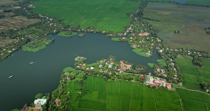 Aerial view of the Alleppey backwaters in Kerala, featuring lush green islands,  village houses, and calm waterways, showcasing the scenic beauty of this popular tourist destination in South India.