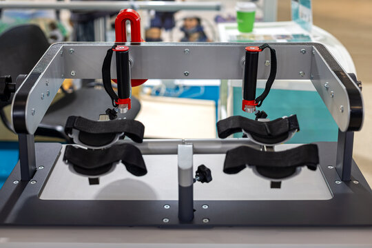 Upper Limb Rehabilitation Exercise Device with Arm Supports. Mechanical rehabilitation device with padded arm supports, straps and upright handles displayed indoors.
