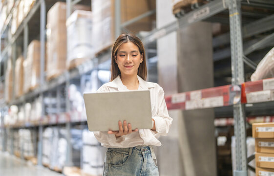 Female engineer is handling shipping and checking stock inventory in the warehouse with a laptop, industry, import-export, inventory management, logistics, global transportation at warehouse, business