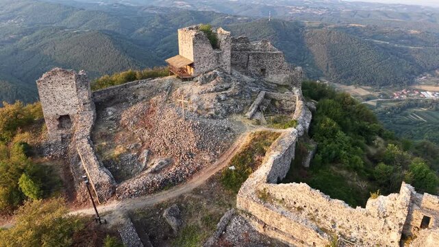 Aerial view of the historic Jerinin Grad fortress ruins on a hilltop surrounded by lush green hills and stone walls in Grabovac, Raski okrug, Serbia.
