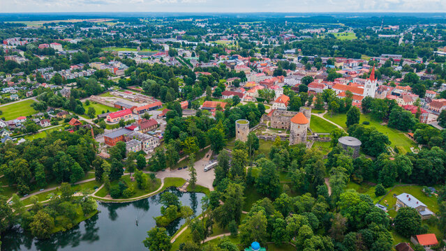 Aerial overview of historic Cesis town showing red tile roofs, medieval castle ruins, and green parkland in Vidzeme region, Latvia