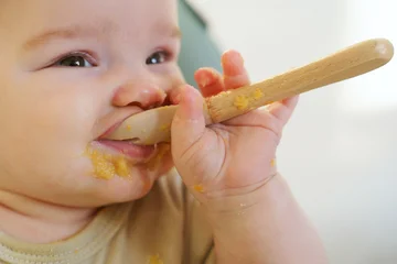 First solids: Baby tries vegetable puree - a touching moment of growing up © olgasparrow
