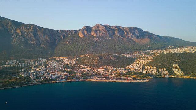 Aerial view of the coastal town of Kas nestled between the Mediterranean Sea and rugged mountains in Kas, Antalya, Turkey.