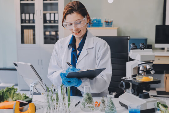 Scientists in lab coats work with plants in a modern lab, focusing on research and experimentation under bright, sterile conditions.