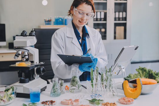 Scientists in lab coats work with plants in a modern lab, focusing on research and experimentation under bright, sterile conditions.