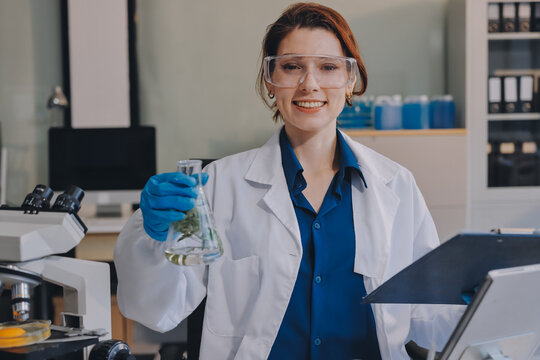 Scientists in lab coats work with plants in a modern lab, focusing on research and experimentation under bright, sterile conditions.