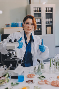 Scientists in lab coats work with plants in a modern lab, focusing on research and experimentation under bright, sterile conditions.