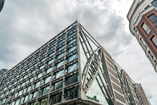 View of the iconic Lloyd's building in London, showcasing its distinctive modern glass facade and external steel structure under a cloudy sky in London, England, United Kingdom.