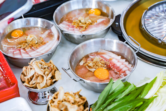 Thai Pork BBQ Buffet (Mu Kratha) &ndash; Delicious grilled sliced pork and fresh vegetables on a traditional dome skillet. Perfect for street food, Asian cuisine, and dining background graphics.