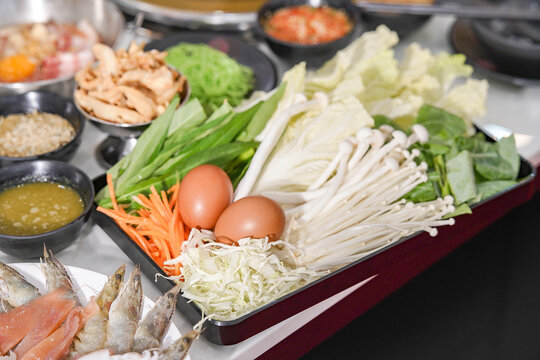 Thai Pork BBQ Buffet (Mu Kratha) &ndash; Delicious grilled sliced pork and fresh vegetables on a traditional dome skillet. Perfect for street food, Asian cuisine, and dining background graphics.