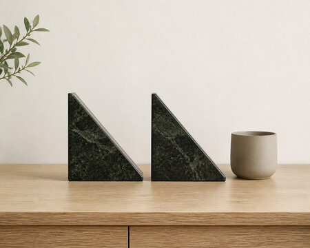 Two identical triangular bookends in row on oak desk with ceramic cup, minimalist desk organization concept