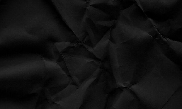 Dark black crumpled paper texture background with creased surface and dramatic shadows Background
