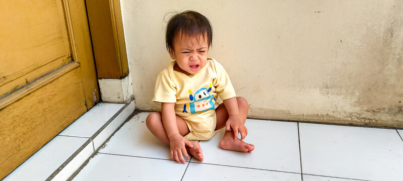 Bright one year old toddler laughing warmly outdoors