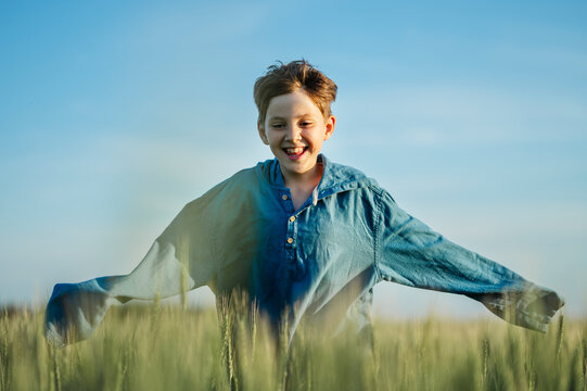 A boy runs across a green field outdoors