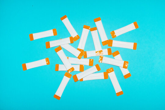 White and orange vitamin sachets mockup on blue background
