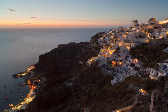 Greece, Cyclades, Thira, Santorini, View of Oia and windmills after sunset