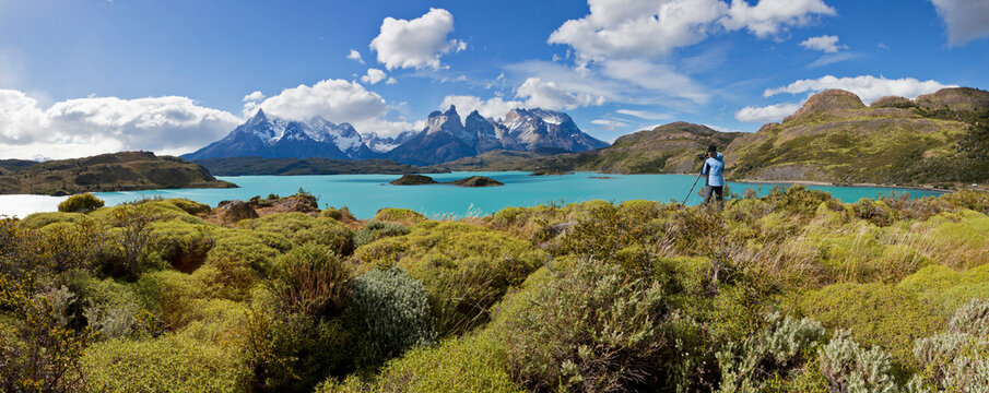 South America, Chile, Patagonia, Torres del Paine National Park, Cuernos del Paine from Lake Pehoe, female photographer standing beside lake