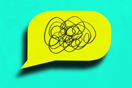 Yellow speech bubble with tangled scribble shows communication barrier