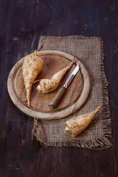 Parsley roots and peeler on wooden board