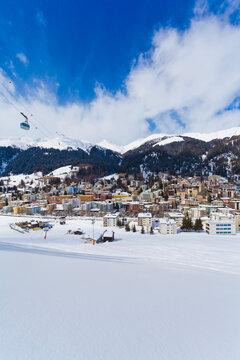 The Jakobshorn cable car crosses the snowy cityscape of Davos